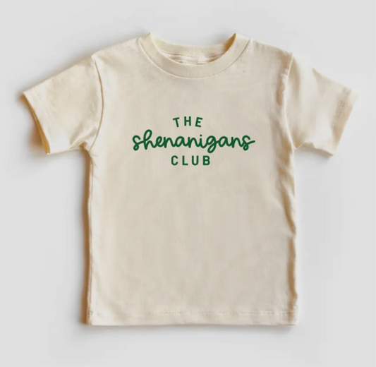 A cream colored short sleeve shirt that says The Shenanigans Club in green font.